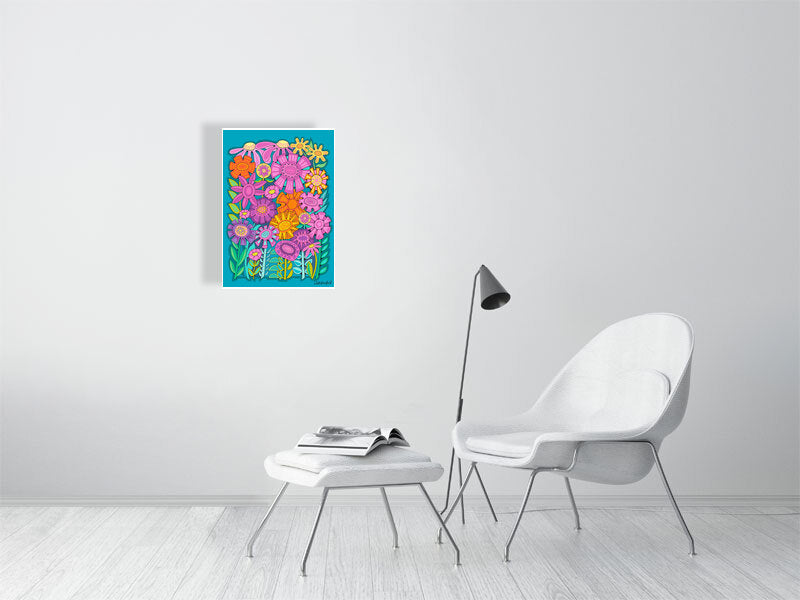 Colorful floral wall art on a white wall above a white chair and ottoman.