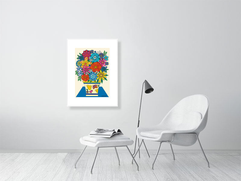 Colorful floral artwork framed in white frame on a white wall above a white chair and ottoman.
