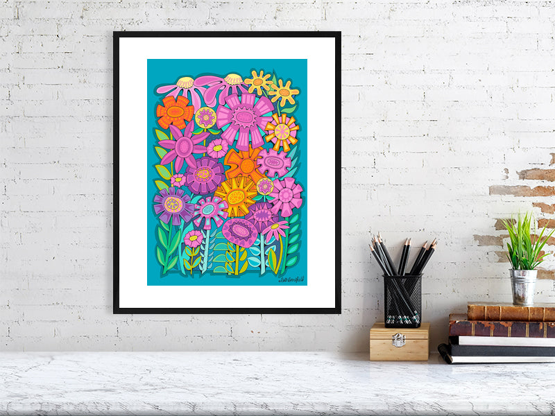 Colorful floral artwork in a black frame on a white brick wall.