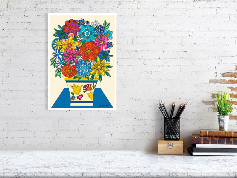 Colorful floral artwork on a white brick wall above a desk.