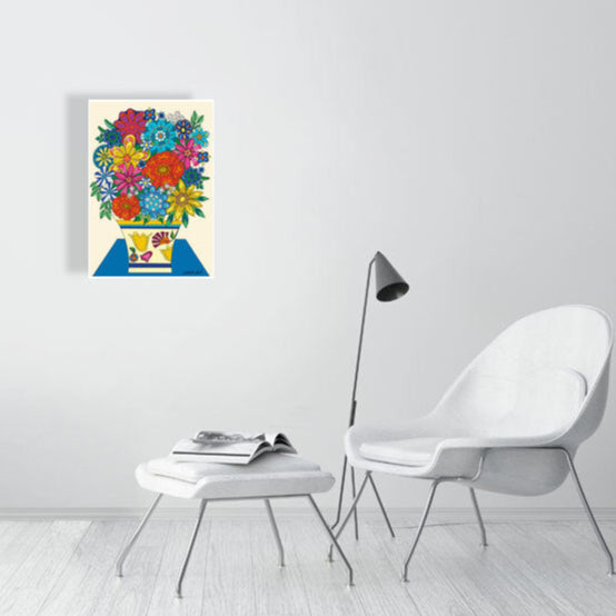 Colorful floral artwork on a white wall above a white chair and ottoman.