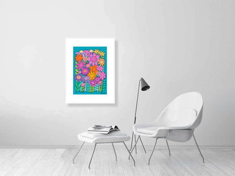 Framed floral artwork on a white wall above a white chair and ottoman.
