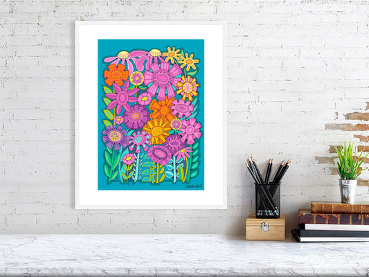 Colorful floral artwork on a white brick wall with a desk and books in the foreground.