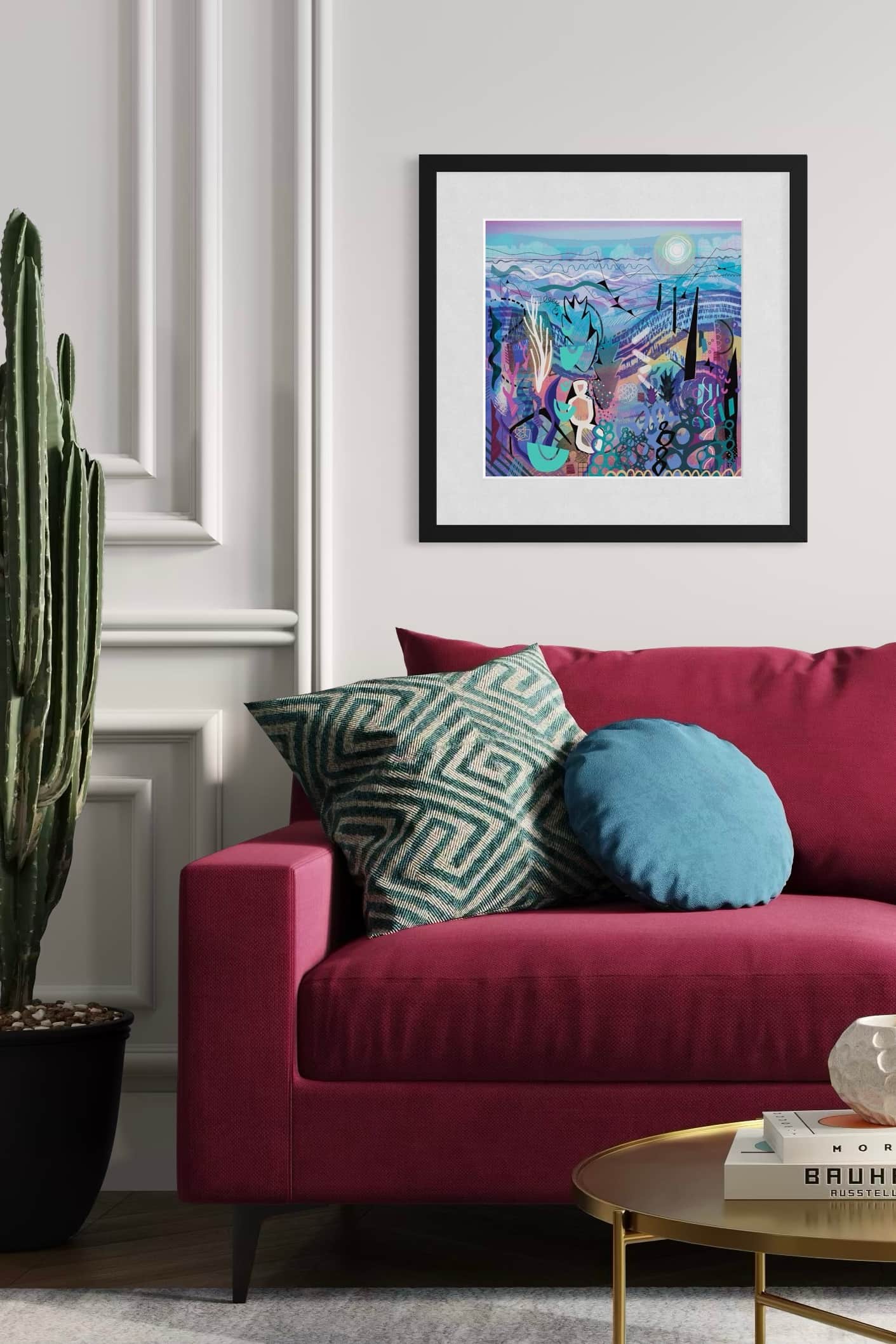 Living room with a red sofa, colorful pillows, and a framed abstract art print by UK artist Ruth Dronsfield on the wall.