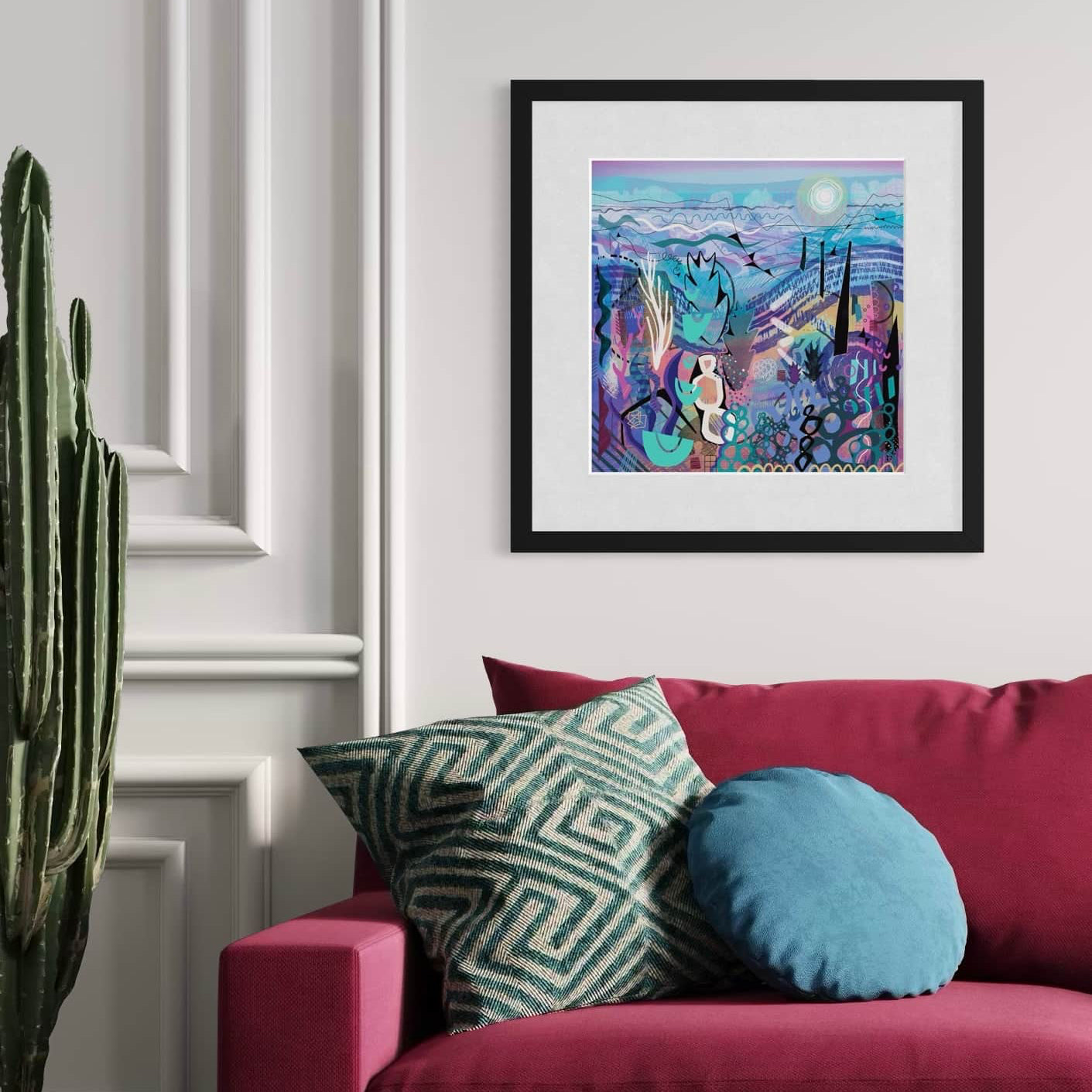 Living room with a red sofa, colorful pillows, and a framed abstract art print by UK artist Ruth Dronsfield on the wall.