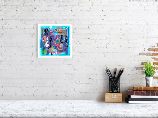 Abstract art print by Ruth Dronsfield hanging on a white brick wall above a desk with pencils and books