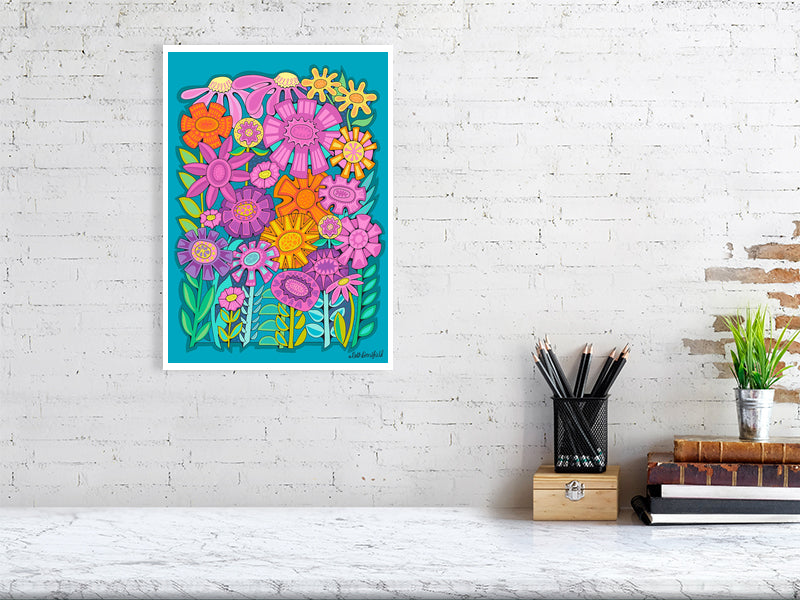 Colorful floral artwork on a white brick wall with a desk and books in the foreground.