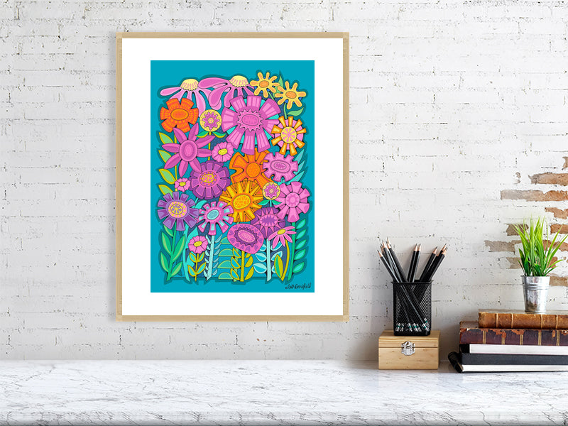 Colorful floral artwork in an oak frame on a white brick wall.