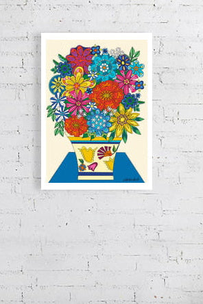 Colorful floral Vintage Vibes Bouquet by UK artist Ruth Dronsfield. On a white brick wall above a desk with stationery items.