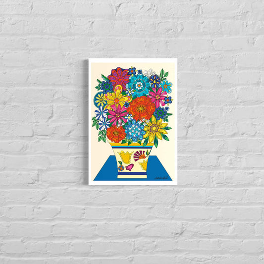 Colorful floral giclée art print called‘Vintage Vibes Bouquet’ by UK artist Ruth Dronsfield. Multicoloured Stylised floral forms with a patterned vase on a bright blue surface with a cream background. Shown unframed On a white brick wall .