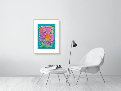 Framed floral artwork on a white wall above a white chair and ottoman.