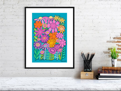 Colorful floral artwork in a black frame on a white brick wall.