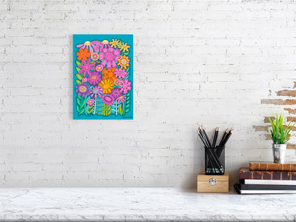 Colorful floral artwork on a white brick wall above a desk.