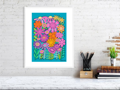 Colorful floral artwork on a white brick wall with a desk and books in the foreground.