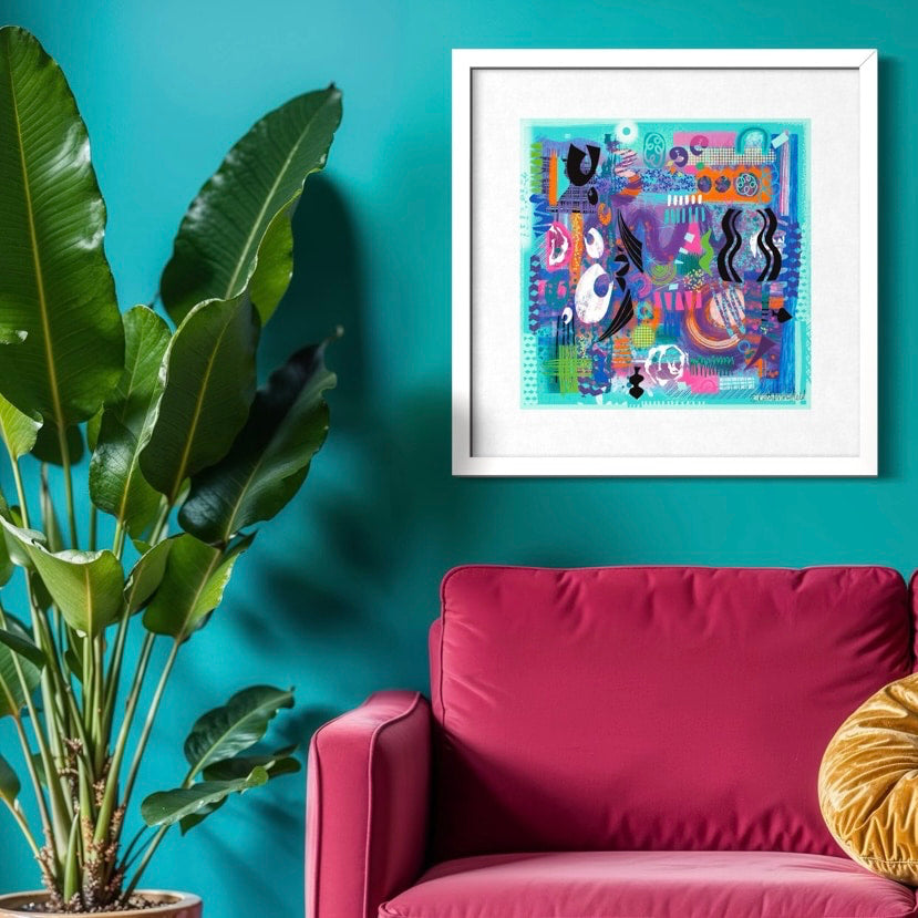 Colorful square abstract art on a teal wall above a pink chair with a plant to the left. The art print has Aqua green and colourful shapes and shown in a white frame 