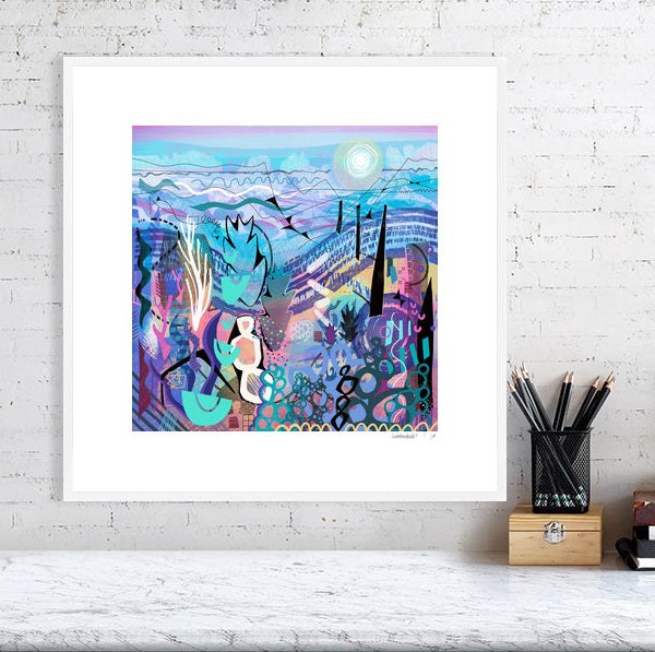 A framed version of the abstract artwork 'Mauve' by Ruth Dronsfield]. The intricate blue and purple print is shown mounted and finished in a clean, modern white gallery frame, styled on a bright wall above a white desk.