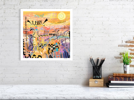 An unframed limited edition abstract art print titled 'Sunburst' by Ruth Dronsfield. The artwork features vibrant layers of yellow and orange with intricate colourful details and geometric patterns. Displayed as a square fine art print on a white brick wall.
