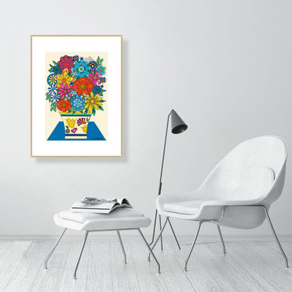Framed colorful artwork of flowers on a wall in a modern room with a chair and lamp.