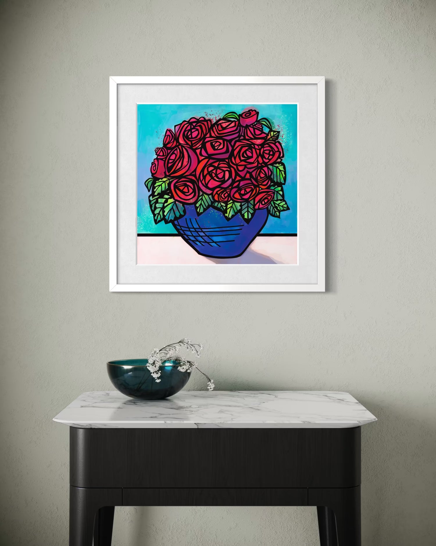 picture of framed print of red roses in a blue bowl hung on a grey wall above a side table