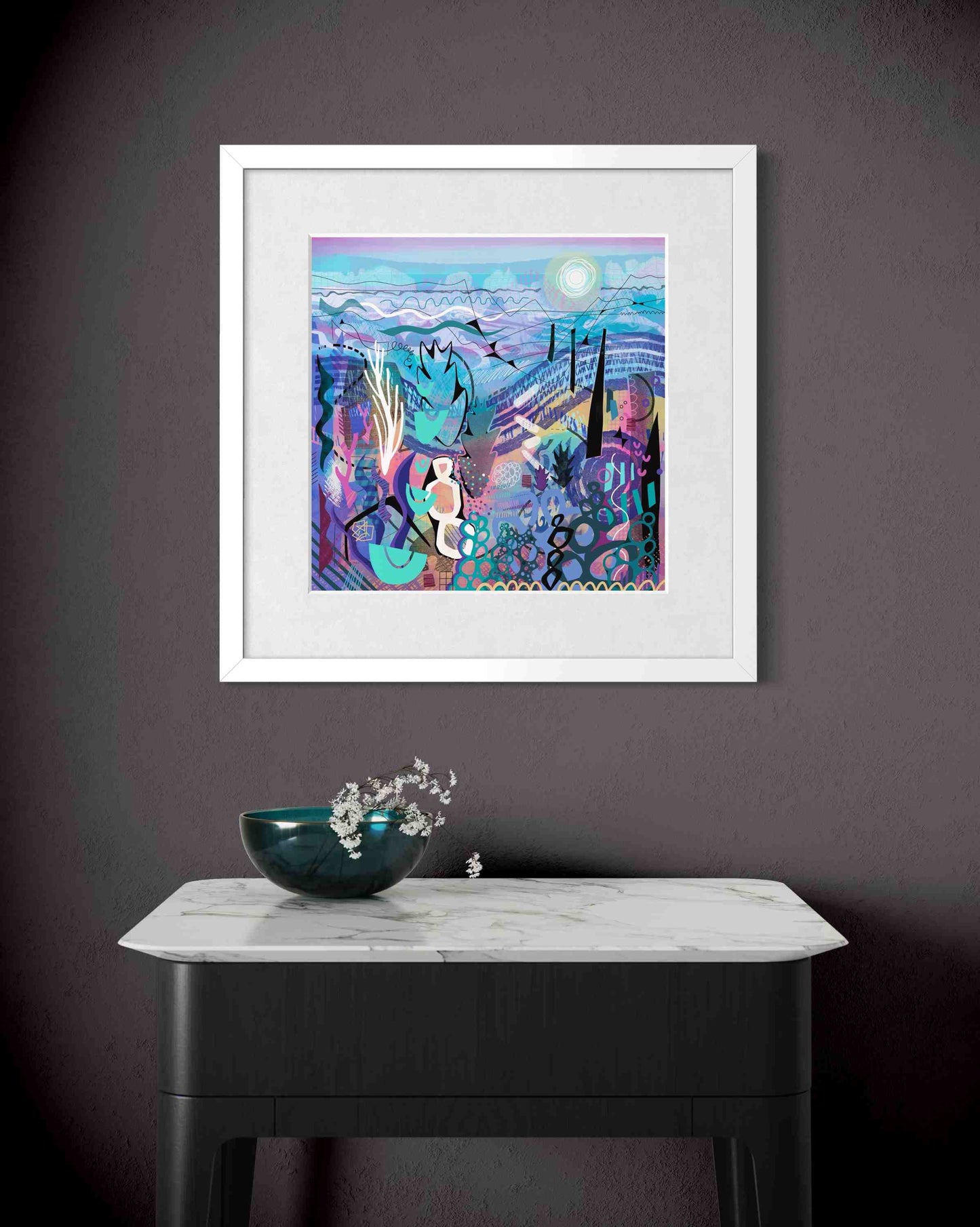 mauve framed in white on a dark grey wall above a table with a decorative bowl.