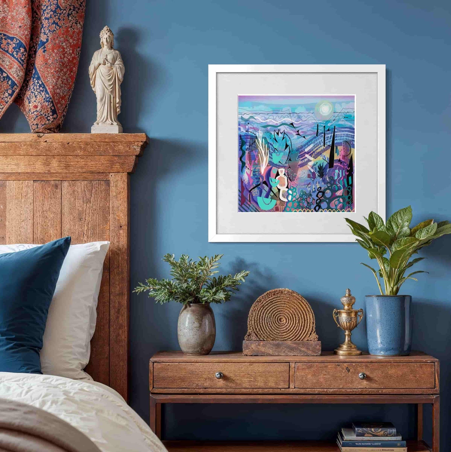Decorative bedroom with a blue wall and wooden headboard, framed 'Mauve' abstract art print by UK artist Ruth Dronsfield