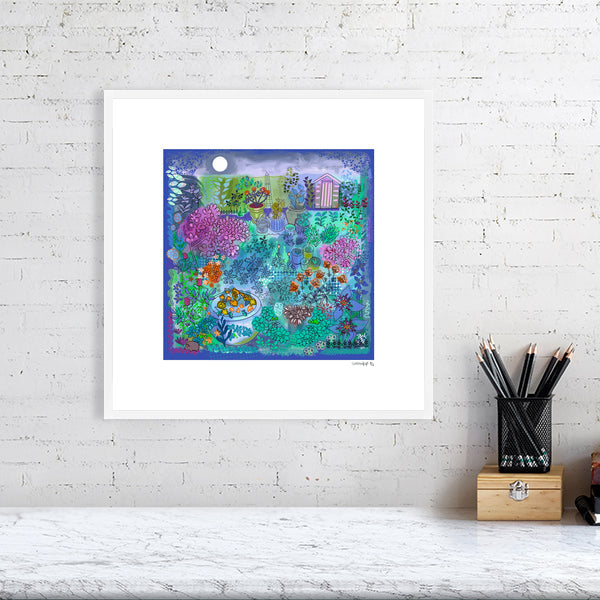 midnight garden fine art print in purples, pinks, and greens with colourful details of shed, plants, moon and hedgehog by Uk artist Ruth Dronsfield. Framed in white hanging on a brick wall above a table with stationary
