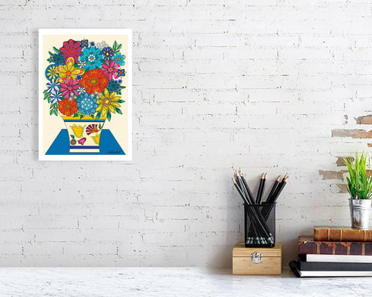 Colorful floral Vintage Vibes Bouquet by UK artist Ruth Dronsfield. On a white brick wall above a desk with stationery items.